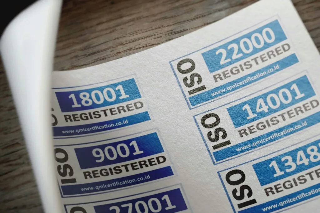 pexels-photo-12324202-12324202 ISO certification stickers with registration numbers on paper.